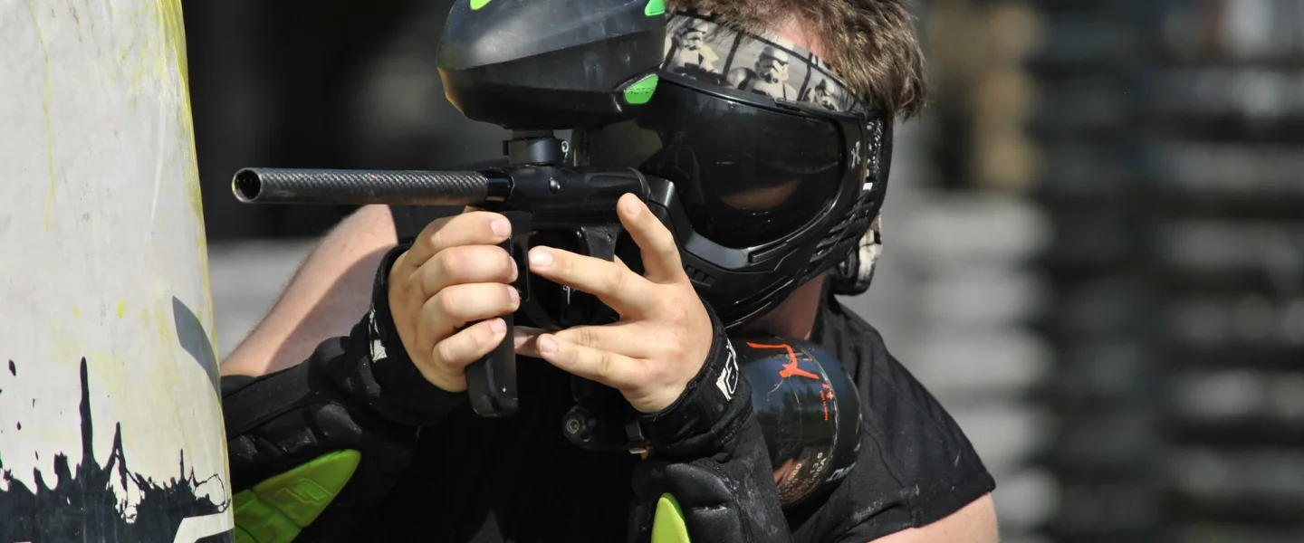 Gracz paintballowy za przeszkodą