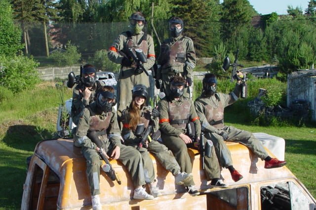 Grupa paintballowa siedząca na samochodzie dostawczym.