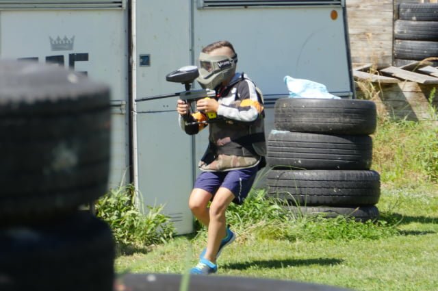 Paintball dla dzieci - dziecko w stroju paintballowym podczas gry w paintball.
