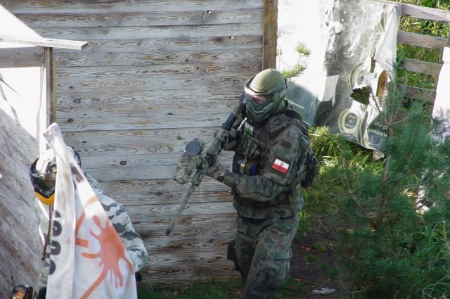 Gracz w mundurze podczas gry w paintball.